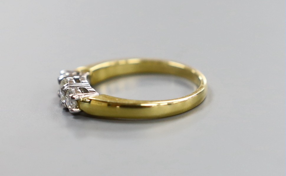 A modern 18ct gold and plat, three stone diamond set ring, size M, gross weight 4.1 grams